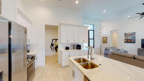 a kitchen with a sink and a living room at Inland home with pool and walk to Park/Museum/Library in Marco Island