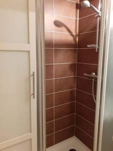 La salle de bains est pourvue d'une douche et de carrelage brun. dans l'établissement Appartement vue mer 4 personnes, à Les Bains