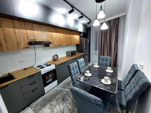 una cucina con tavolo e sedie in una cucina di Lux apartments in Turkistan a Türkistan