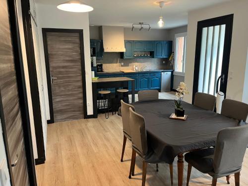 une cuisine et une salle à manger avec une table et des chaises dans l'établissement La maison dans les bois, à Crayssac