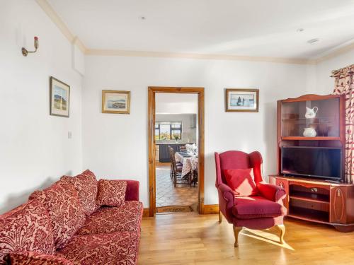 a living room with a couch and a tv and a chair at McDara Island View in Carna