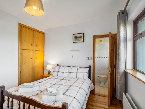 a bedroom with a bed and a bathroom with a toilet at McDara Island View in Carna