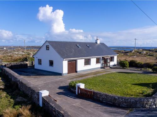 a small white house with a large yard at McDara Island View in Carna