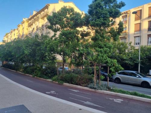une rue avec des arbres sur le côté d'un bâtiment dans l'établissement Beau T2 proche Negresco, à Nice
