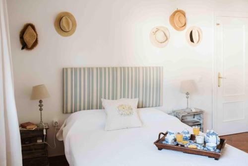 un letto bianco con un vassoio di cibo sopra di CASA BUGANVILLA a Barbate