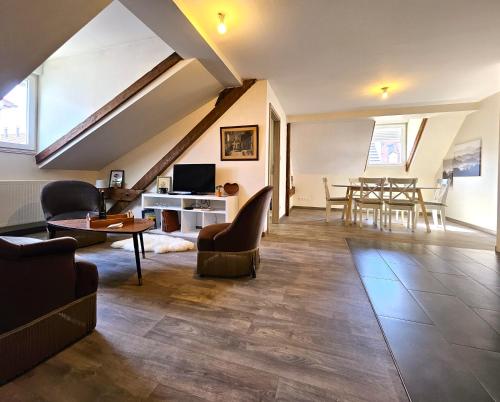 - un salon mansardé avec une table et des chaises dans l'établissement ThannT3-Centre Ville-Garage privé, à Colmar