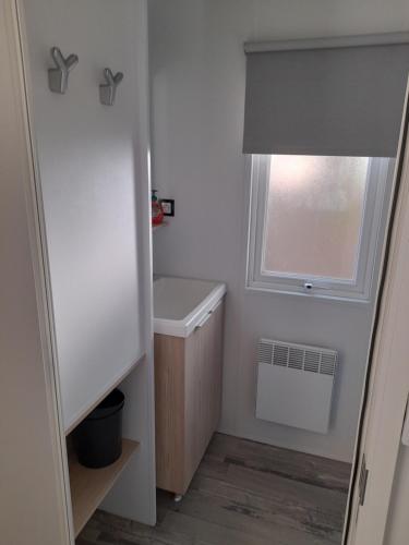 a small bathroom with a sink and a window at RIVA BELLA Lodge 171 in Ouistreham