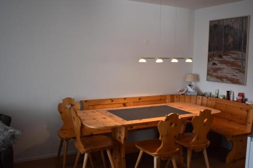 a wooden table and chairs in a room at Haus im Park 11 in Valbella