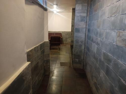 a hallway with a brick wall and a table and chairs at zoz sm7 in Shimla