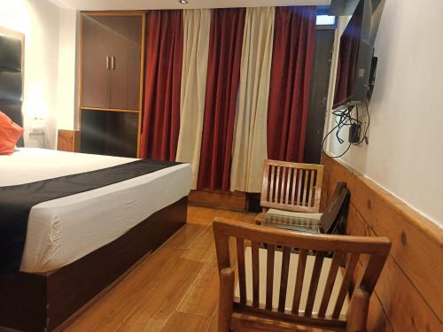 a bedroom with a bed and a chair and a television at zoz sm7 in Shimla