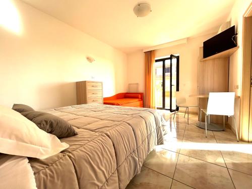 a bedroom with a bed and a couch and a television at Hotel Park in Rossano