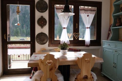 a kitchen with a table and chairs and windows at Residence Fontanazzo in Campitello