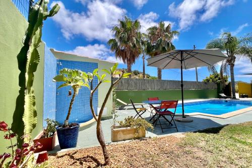 a patio with a table and an umbrella next to a pool at Country Villa work&relax in Lagos
