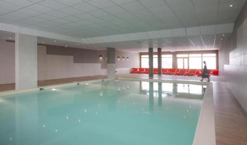 - une piscine dans une pièce avec une personne qui s'y promet dans l'établissement Appartement Luxe Avec Vue : Au Pied des Pistes, à Sainte-Foy-Tarentaise