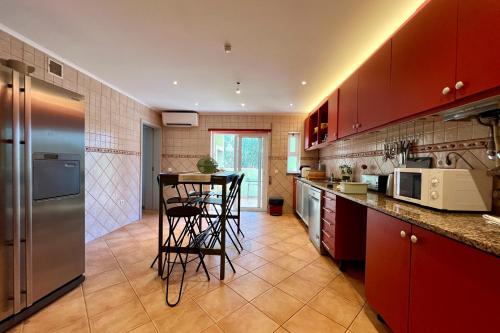 a kitchen with red cabinets and a counter top at Country Villa work&relax in Lagos
