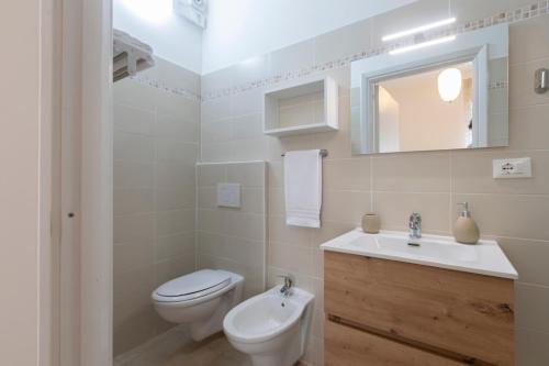 a white bathroom with a toilet and a sink at B&B Amerigo Vespucci in Marina San Vito