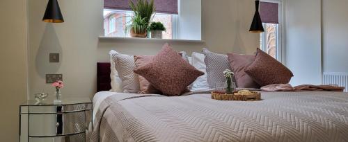 a bedroom with a large bed with pink and white pillows at Arkle in Kelling