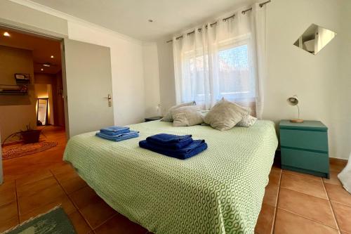 a bedroom with a bed with two blue towels on it at Country Villa work&relax in Lagos