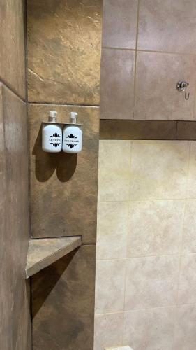 a bathroom with two soap dispensers in a shower at Hotel del Rio - La Cruz Corrientes in La Cruz