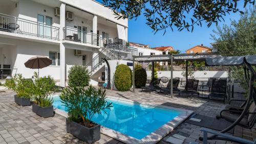 a courtyard with a swimming pool and a building at TayLa-Apartment Vodice in Vodice
