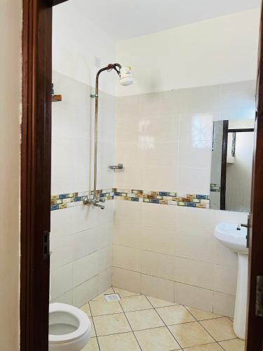 a bathroom with a toilet and a sink at Tranquil space with aerial Mombasa view in VOK off nyali road in Kisauni
