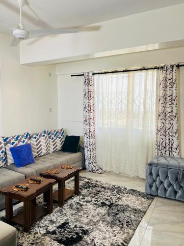 a living room with a couch and a table at Tranquil space with aerial Mombasa view in VOK off nyali road in Kisauni