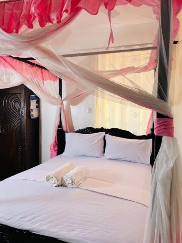 a bedroom with a bed with two towels on it at Tranquil space with aerial Mombasa view in VOK off nyali road in Kisauni