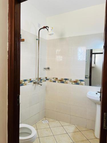a bathroom with a toilet and a sink at Tranquil space with aerial Mombasa view in VOK off nyali road in Kisauni