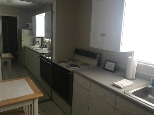 a kitchen with a black stove and a sink at INN LEATHER GUEST HOUSE-GAY MALE ONLY in Fort Lauderdale