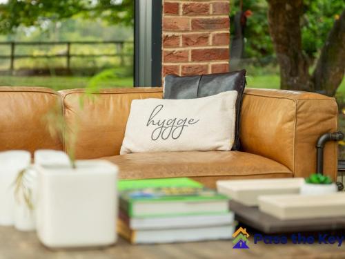 a brown couch with a pillow that reads turkey out at Country House, 4 Acres, Views & Swimming Pool in Stockcross