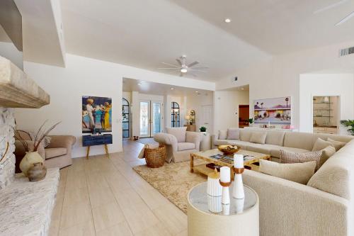 a living room with white furniture and a fireplace at Escape to Paradise Valley in Indian Wells