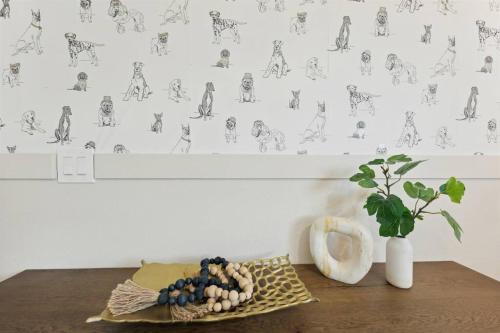 a table with a vase and a plant on a wall at Dog Family Paradise in Tempe