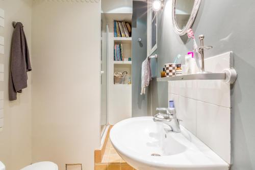 une salle de bain avec un lavabo et un miroir dans l'établissement GOBELINS-Saint Médard, à Paris