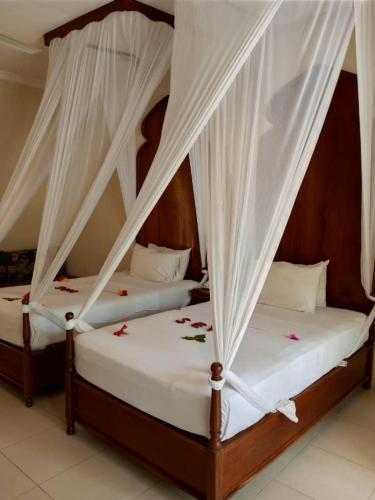 Ένα ή περισσότερα κρεβάτια σε δωμάτιο στο Sunset Kendwa Beach Hotel