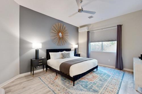 Un dormitorio con una cama y una ventana grande. en Vista Oasis Retreat, en Cathedral City