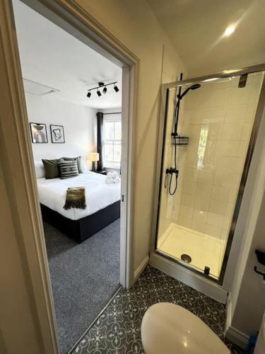 a bathroom with a shower and a bedroom with a bed at Central Chic 3 bed, Great Location in Winchester