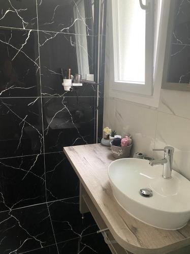 a bathroom with a sink and a black shower at Arletos Home in Ioannina