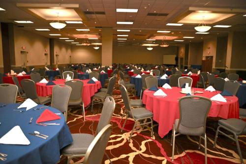 a banquet hall with red and blue tables and chairs at MCM Elegante Hotel & Suites Lubbock in Lubbock
