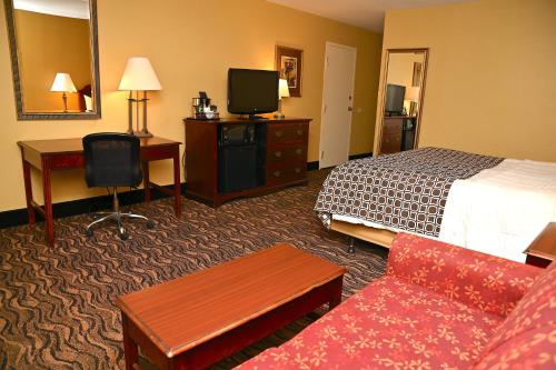 a hotel room with a bed and a desk at MCM Elegante Hotel & Suites Lubbock in Lubbock