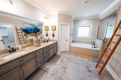 Un baño con dos lavabos y una bañera y una escalera. en Insurance Housing Fully Furnished & Stress-free, en Sherwood