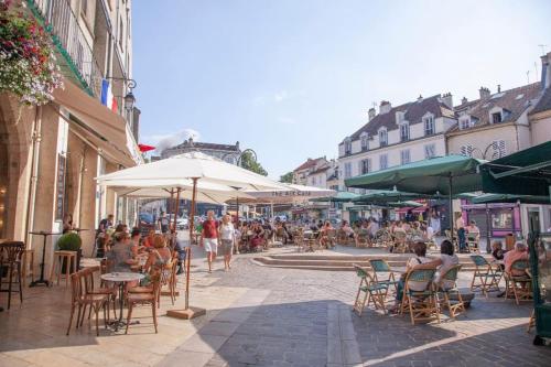 a group of people sitting at tables on a city street at appartement la boheme, Disney 15 min, Paris 25 min in Thorigny-sur-Marne
