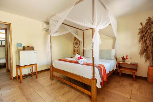 a bedroom with a canopy bed with a teddy bear on it at Finca Escondida in Palomino
