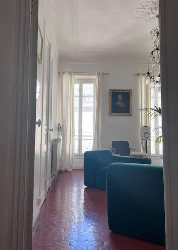 - un salon avec des canapés bleus et une fenêtre dans l'établissement Grand appartement lumineux, à Marseille