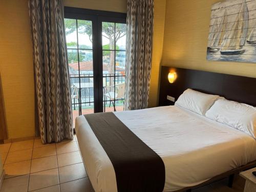 a bedroom with a bed and a large window at Hotel Canal Olímpic in Castelldefels