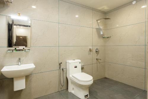 a bathroom with a toilet and a sink and a shower at The Lotaz Hotel in Cochin