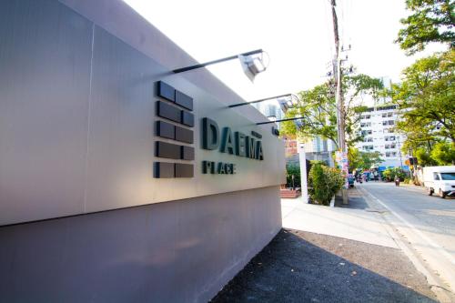a building with a sign on the side of a street at Dae Ma Place in Nonthaburi