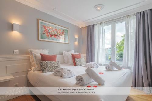 a bedroom with a large white bed with towels on it at Au 30 Lille Centre Grand Palais in Lille