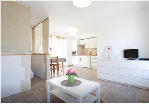 un salon avec une table et une cuisine dans l'établissement Charmant studio, à Fontvieille