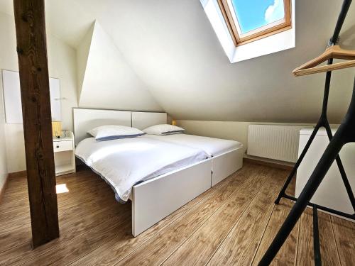 une chambre avec un lit blanc dans un grenier dans l'établissement ThannT3-Centre Ville-Garage privé, à Colmar