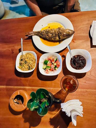 a table with plates of food and bowls of food at Star Eyes Hostel in Weligama